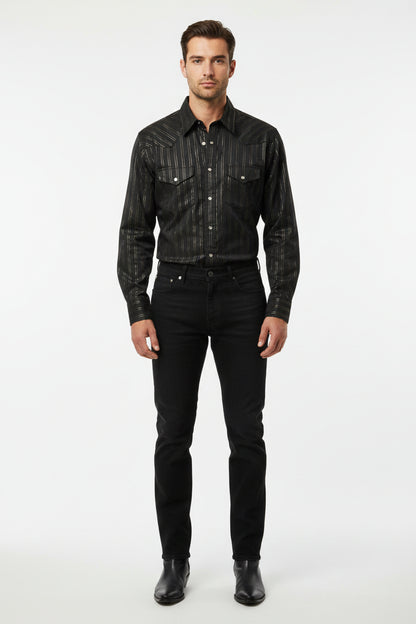 A black long-sleeve button-up shirt with thin vertical metallic gold stripes, laid flat on a beige carpet next to a blue rug.
