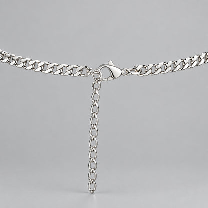 A silver metal chain necklace with a lobster clasp and an adjustable hanging extender chain, displayed on a black velvet jewelry bust.