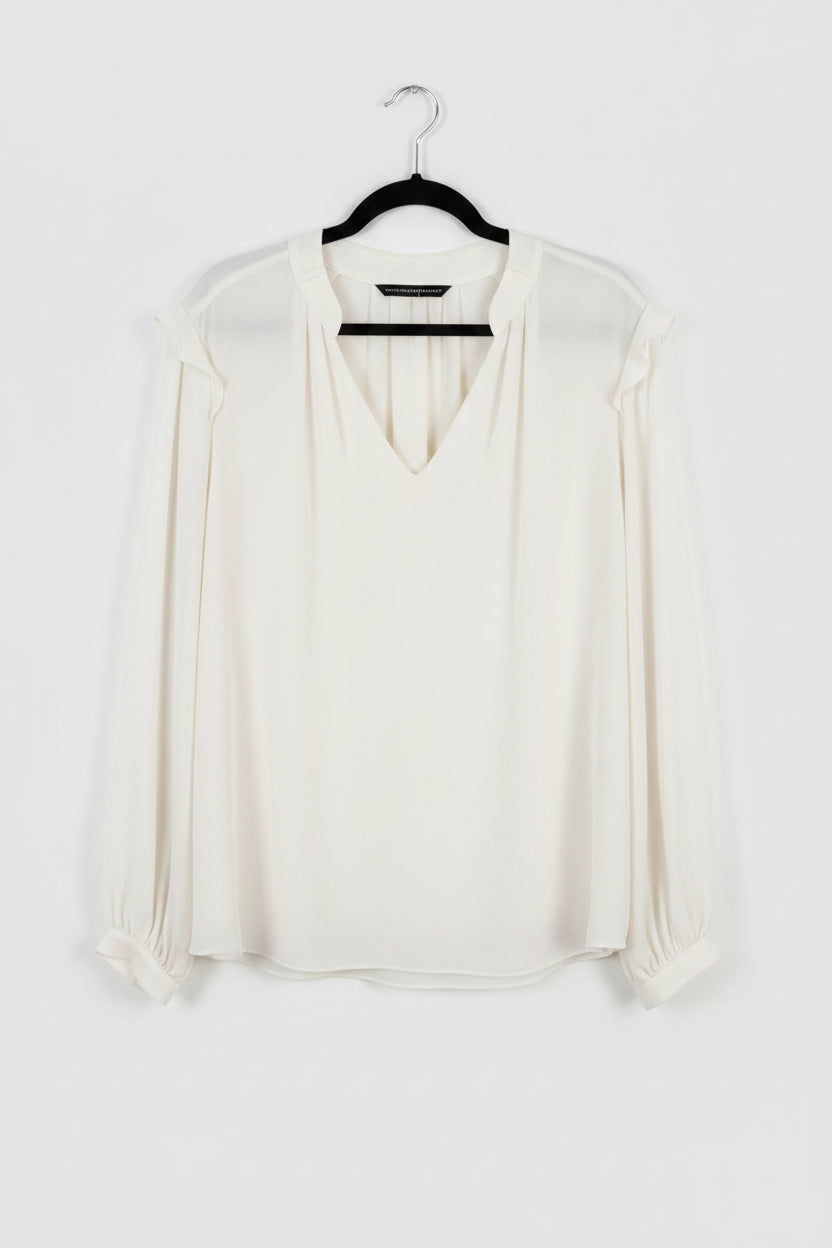 White blouse on a hanger against a white background