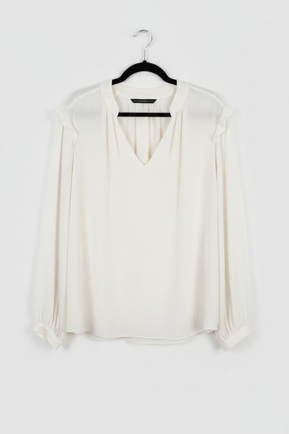 White blouse on a hanger against a white background
