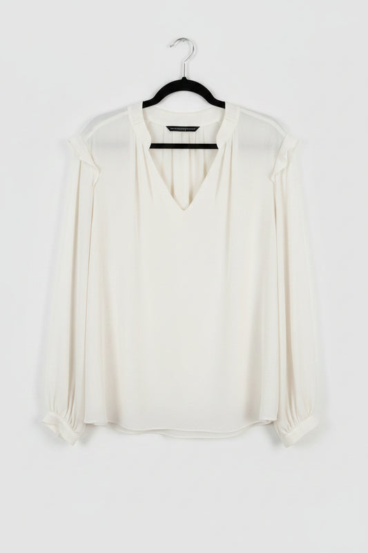 White blouse on a hanger against a white background