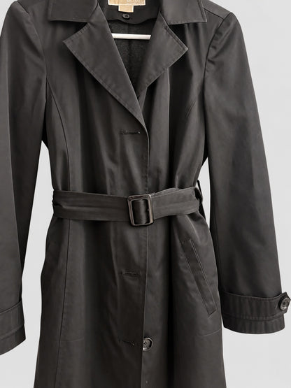A black trench coat with a matching waist belt and buckle, shown on a hanger against a light gray background.