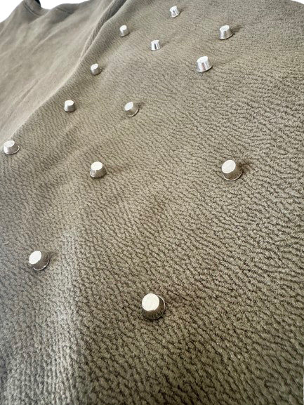Close-up of a textured fabric surface with metallic studs.