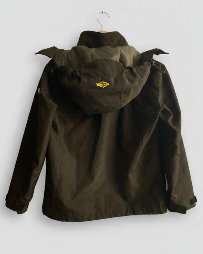 An olive green hooded jacket hanging on a wooden hanger against a light gray background, showing the back view with a small yellow logo on the hood.