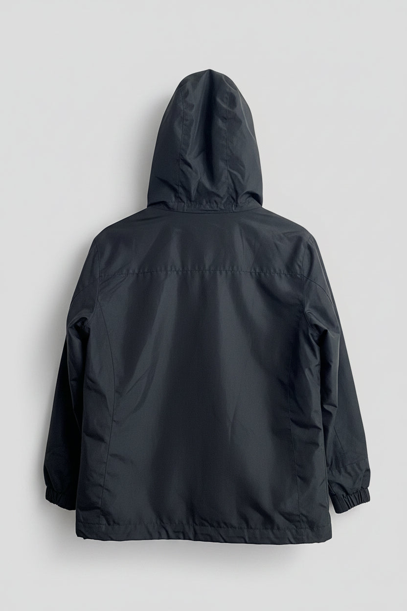 A dark gray hooded rain jacket shown from the back, hanging against a white interior door.