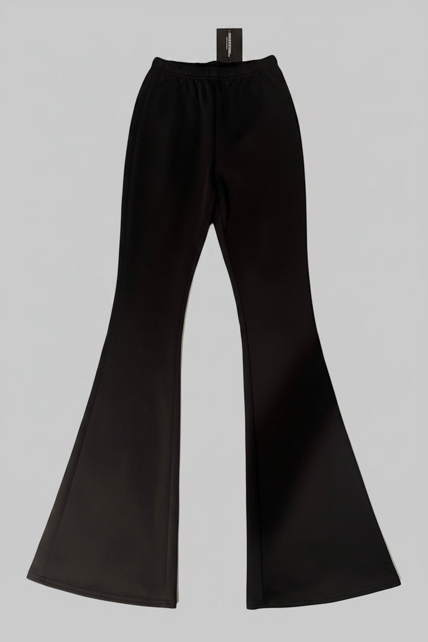 Black flared pants on a textured surface