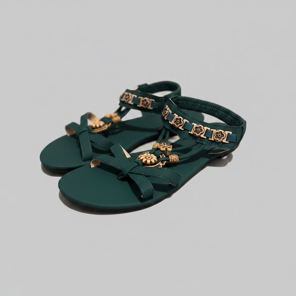 Green sandals with gold embellishments on a textured surface