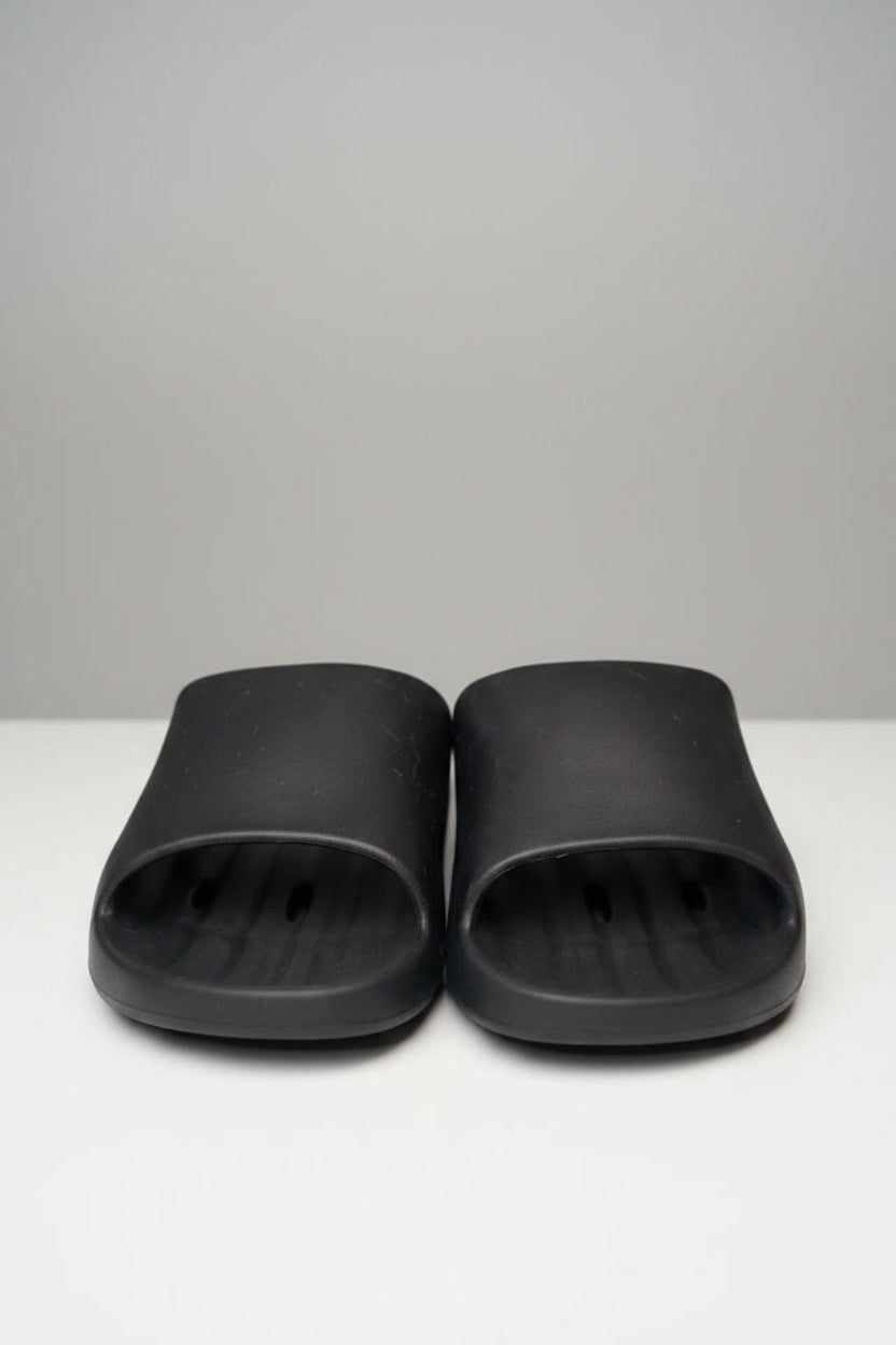 Pair of black slides on a gray surface