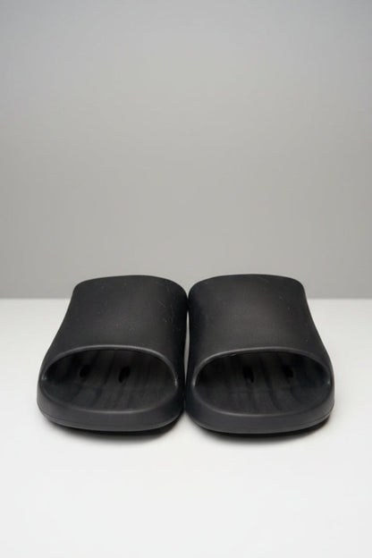Pair of black slides on a gray surface