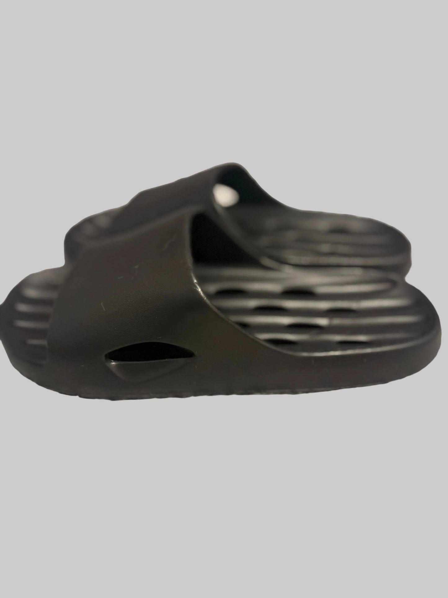 Black sandal on a textured gray surface