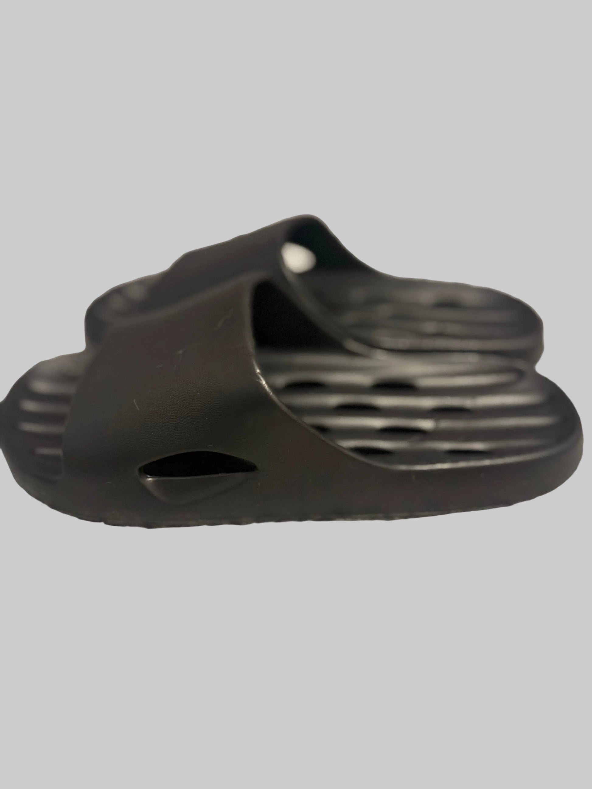 Black sandal on a textured gray surface