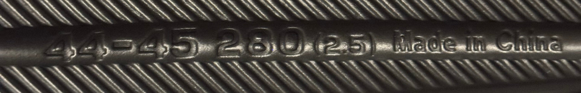 Close-up of bottom of shoe with engraved text on a carpeted floor.