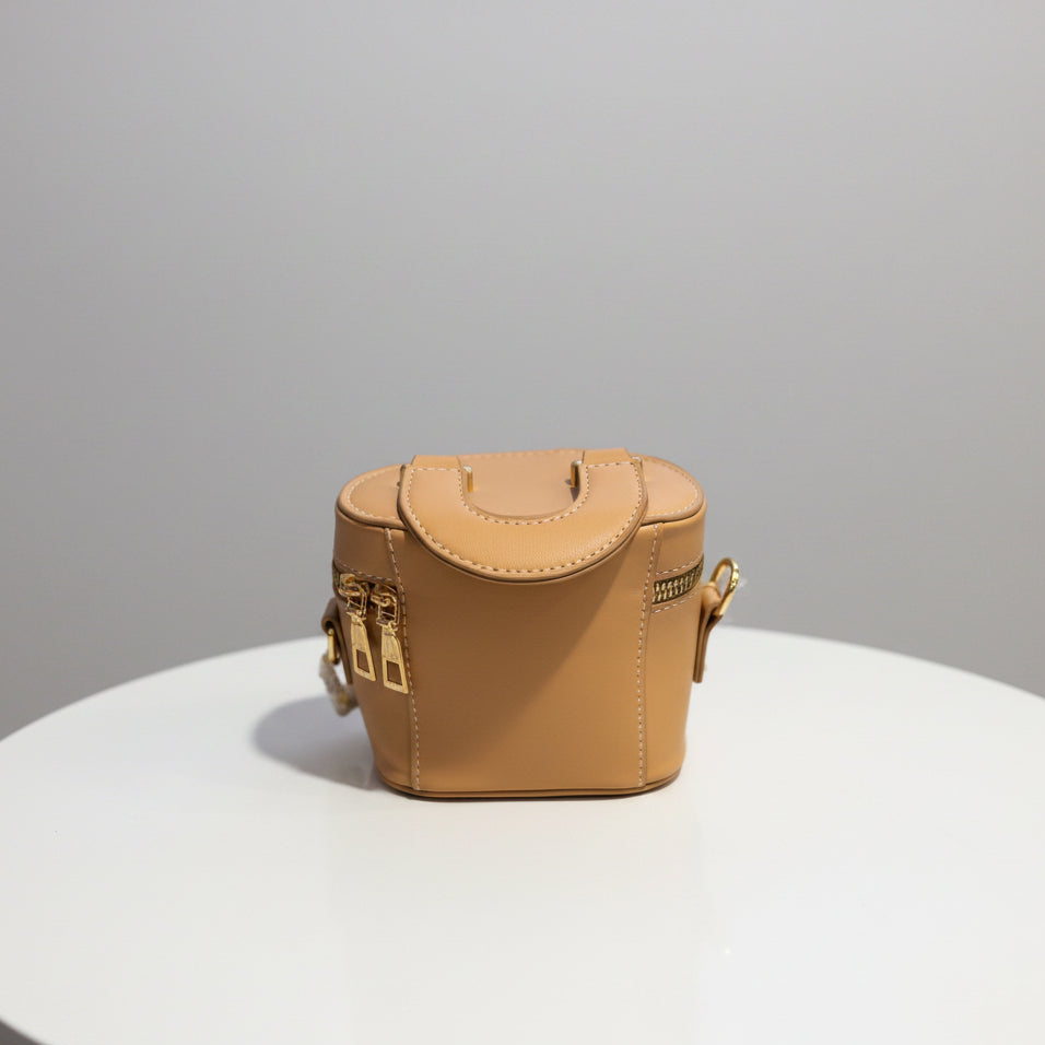 Small tan leather bag on a textured surface