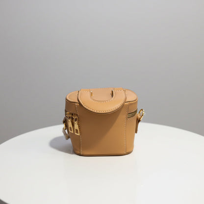 Small tan leather bag on a textured surface