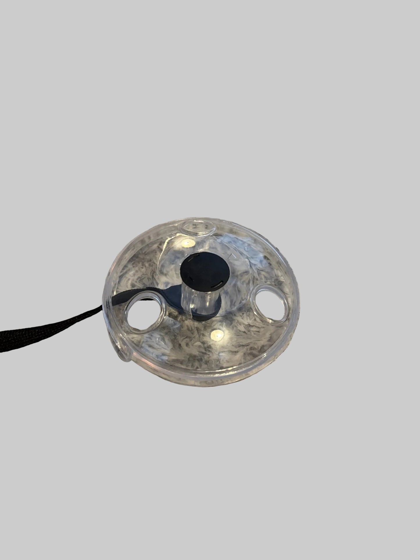 Clear plastic lid with black interior on a textured surface
