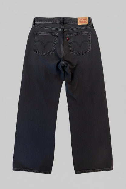 Pair of Levi's jeans on a white surface with a patterned rug in the background