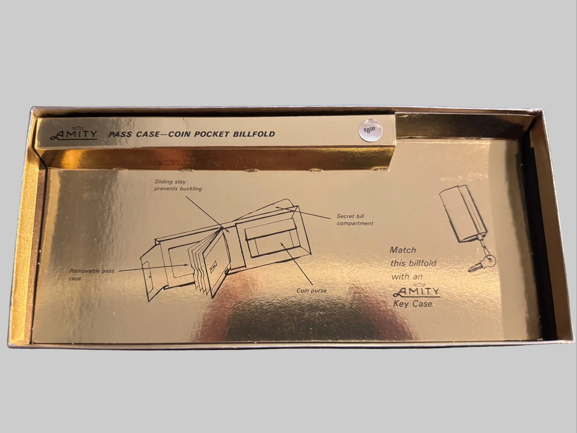 Brass pocket billfold with instructions on a dark background
