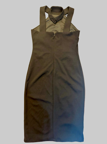 A sleeveless black dress with a mock neck and shoulder cutouts, laid flat on a wooden table.