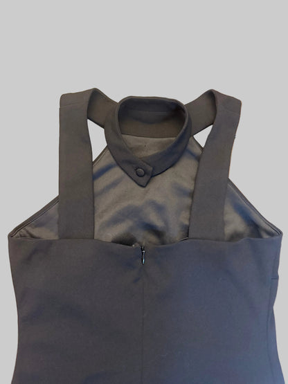 A dark gray sleeveless top with a mock collar and wide shoulder straps, laid flat on a wooden floor.