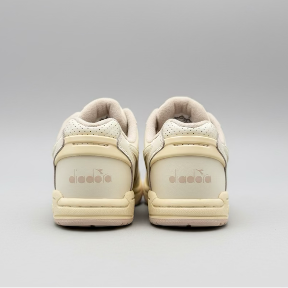 Pair of beige sneakers with 'Diadora' branding on a light gray background