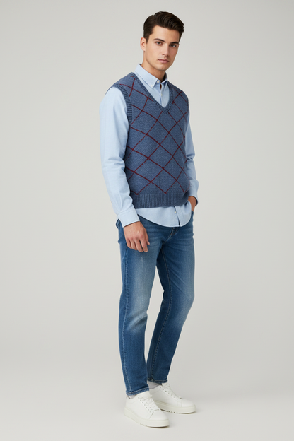 A sleeveless blue knit sweater vest with a red argyle pattern, laid flat against a light gray background.