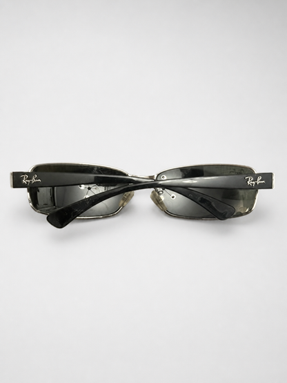 Ray-Ban square rimless sunglasses with dark gray lenses and black acetate arms, displayed on a light gray background.