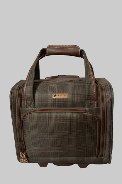 A plaid rolling duffel bag in dark brown and gray with brown leather handles, standing on a gray carpeted floor against a beige wall.
