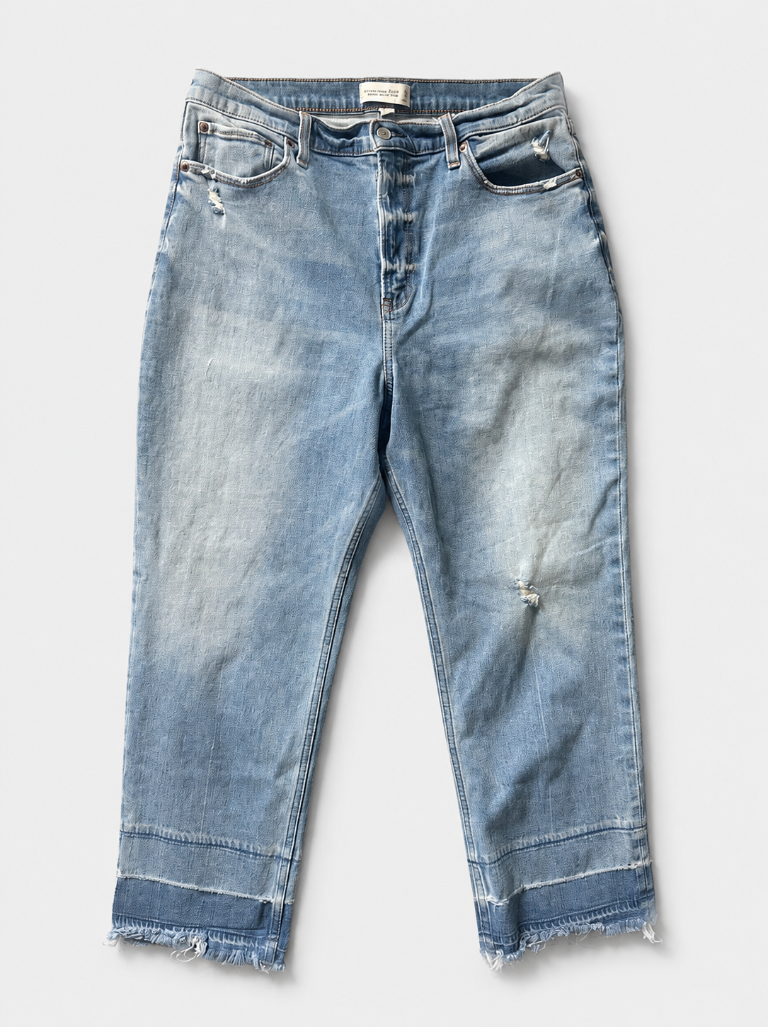 Light blue high-waisted cropped jeans with a faded wash, distressed details, and raw frayed hems, shown flat on a light gray background.