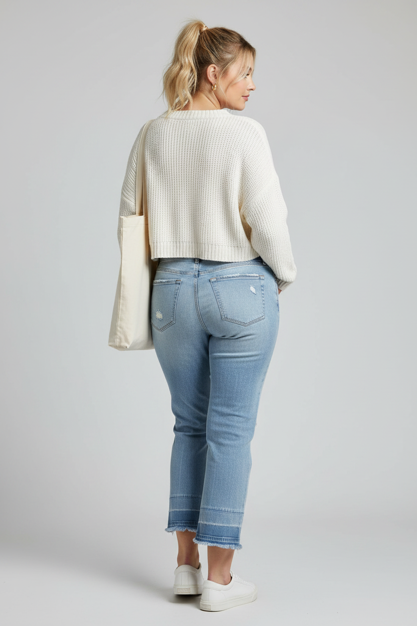Light blue denim jeans shown from the back, featuring distressed details on the back pockets and a raw, frayed hem, laid flat against a light gray background.